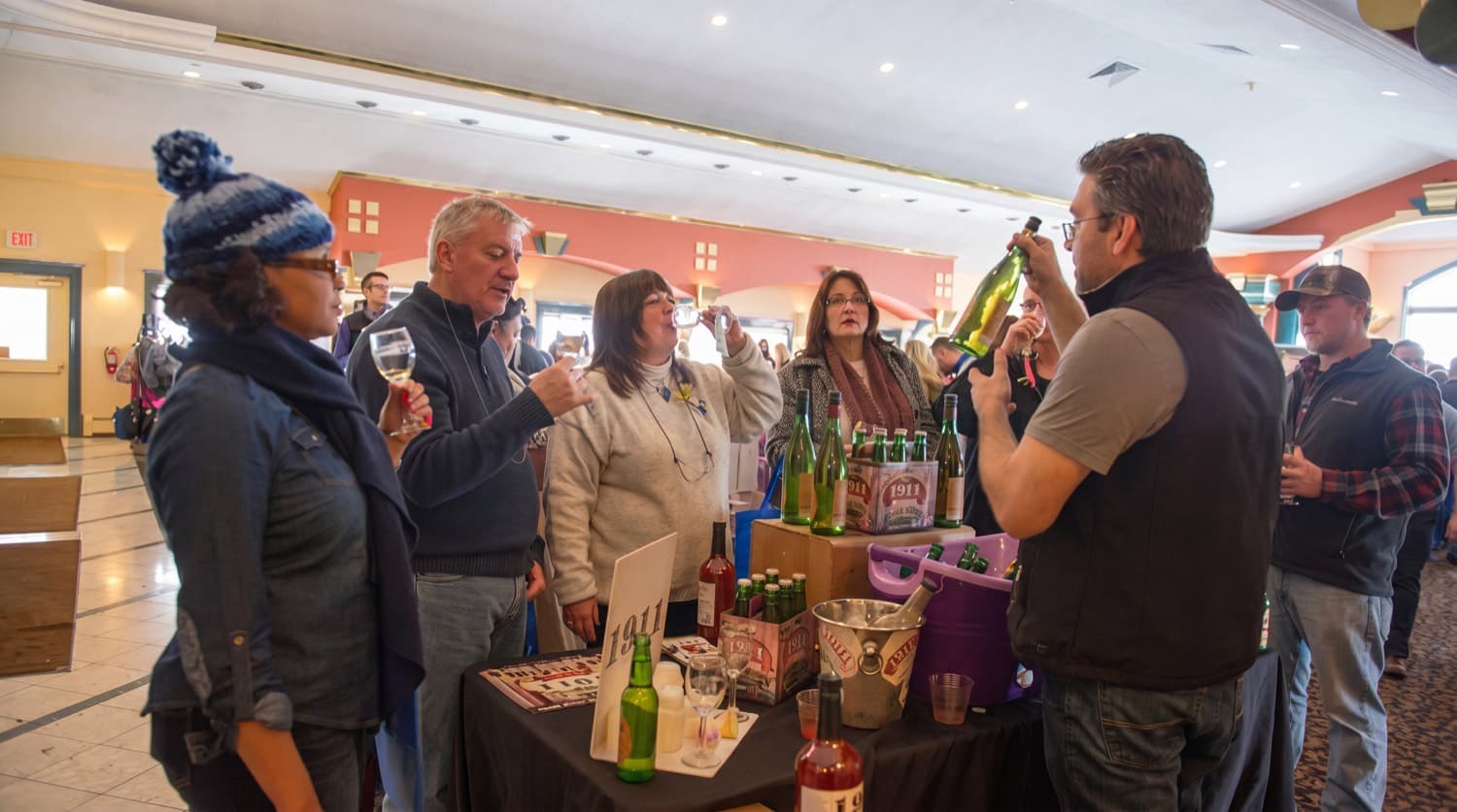 Guests in winter coats tasting Casa Larga wines indoors at the festival