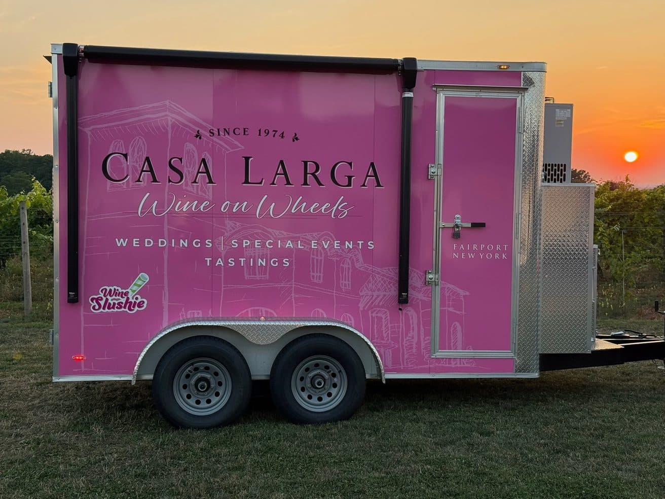 The Casa Larga Wine on Wheels trailer in the vineyard at sunset